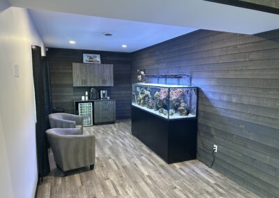 A fish tank in a room with a chair and a table.